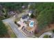 An aerial view of a tan house with a large back yard, pool, and lots of trees at 204 Silvercliff Dr, Mount Holly, NC 28120