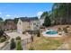 Gorgeous backyard featuring a custom pool with waterfall, landscaping, and an outdoor seating area at 204 Silvercliff Dr, Mount Holly, NC 28120