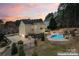 Gorgeous backyard featuring a custom pool with waterfall, landscaping, and an outdoor seating area at 204 Silvercliff Dr, Mount Holly, NC 28120