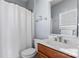 Bathroom with a toilet, sink, mirror and a shower behind a white curtain at 204 Silvercliff Dr, Mount Holly, NC 28120
