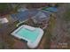 Community pool with a clubhouse, tennis courts, and parking area at 204 Silvercliff Dr, Mount Holly, NC 28120