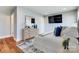 Modern bedroom featuring hardwood floors, a dresser with decor, and a wall-mounted TV for ultimate relaxation at 2123 Isom St, Charlotte, NC 28208