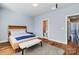 Bright bedroom boasting hardwood floors, a wooden bed frame, and an ensuite bathroom at 2123 Isom St, Charlotte, NC 28208