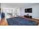 Open-concept living space with hardwood floors, kitchen view, and a large television at 2123 Isom St, Charlotte, NC 28208