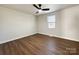 Bedroom features hardwood floors, a ceiling fan, and a large window at 226 Malvern Sw Dr, Concord, NC 28025