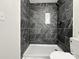 Modern shower featuring sleek dark tile, a convenient built-in niche, and updated fixtures at 226 Malvern Sw Dr, Concord, NC 28025