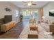 Bright, staged living room with a neutral color palette, large windows, and sliding glass doors to the backyard at 23186 Goose Down Ln, Lancaster, SC 29720