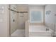 This bathroom features a glass shower and tub combo, plus a modern neutral tile throughout at 2352 Seagull Dr, Denver, NC 28037