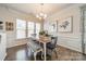 This dining area features hardwood floors, wainscoting, and three large windows with wooden blinds at 2463 Diplomat Ln, Charlotte, NC 28210