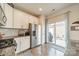 This well-lit kitchen features stainless steel appliances, white cabinets, and access to the outdoor patio at 2463 Diplomat Ln, Charlotte, NC 28210