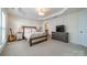 Spacious main bedroom with ensuite bath and modern decor and television at 2463 Diplomat Ln, Charlotte, NC 28210