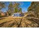 Large backyard with a blue painted house, mature trees, and a well-maintained lawn at 2708 Catalina Ave, Charlotte, NC 28206