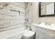 Stylish bathroom with a tub and shower featuring elegant marble-patterned tile and modern vanity at 2708 Catalina Ave, Charlotte, NC 28206