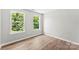 This bright bedroom features two large windows providing ample natural light and hardwood floors at 329 Squirrel Ln, Clover, SC 29710