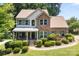 Charming two-story home boasts manicured landscaping, stone accents, and inviting covered front porch at 329 Squirrel Ln, Clover, SC 29710