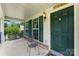 Charming front porch featuring a swing, a chair, and a green front door at 329 Squirrel Ln, Clover, SC 29710
