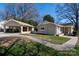 View of the brick home and carport, connected by a paved walkway, set in a well-kept lawn at 4211 Seaforth Dr, Charlotte, NC 28205