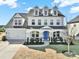 Charming two-story home featuring a blue front door, covered porch, dormer windows, and attached two-car garage at 4707 Kingswood Dr, Fort Mill, SC 29707