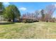 Spacious backyard showcasing the home's exterior and its peaceful, green surroundings on a sunny day at 4937 Lebanon Dr # 1, Charlotte, NC 28273
