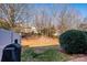 Backyard with lawn, bush, and a grill under bare trees in the neighborhood at 8422 Chaceview Ct, Charlotte, NC 28269