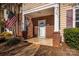 Inviting covered porch with brick columns and patriotic American flag display at 8422 Chaceview Ct, Charlotte, NC 28269