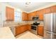 Charming kitchen featuring stainless steel appliances, wood cabinets and neutral countertops at 8422 Chaceview Ct, Charlotte, NC 28269