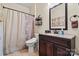 Well-maintained bathroom featuring a modern vanity, toilet, shower with patterned curtain, and neutral color scheme at 8808 Fallsdale Dr, Charlotte, NC 28214