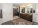 Spacious bathroom featuring a tiled shower with glass doors, double sinks and dark wood cabinets at 8906 Cantrell Way, Huntersville, NC 28078