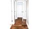 View of the hallway leading to a bedroom, highlighting the hardwood floors and neutral color scheme at 926 Poplar St, Albemarle, NC 28001