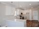 Open-concept kitchen featuring white cabinetry, quartz countertops, stainless steel appliances, and modern pendant lighting at 926 Poplar St, Albemarle, NC 28001