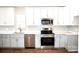 Kitchen boasts stainless steel appliances, white cabinets and granite countertops at 926 Poplar St, Albemarle, NC 28001