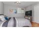 Bedroom features wood floors, a ceiling fan, a TV, and artwork on the wall at 100 Willow Run Dr, Gastonia, NC 28056
