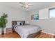 Bedroom featuring hardwood floors, a ceiling fan, and a large bed with views of the backyard at 100 Willow Run Dr, Gastonia, NC 28056