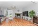 Inviting living room with hardwood floors, stone fireplace, and natural light from the French doors at 100 Willow Run Dr, Gastonia, NC 28056