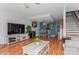Spacious living room with hardwood floors flowing into the dining area and featuring staircase at 100 Willow Run Dr, Gastonia, NC 28056
