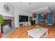 Open-concept living room showcasing stone fireplace, hardwood floors, and adjoining dining area at 100 Willow Run Dr, Gastonia, NC 28056