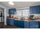 Functional kitchen featuring ample counter space, blue cabinets and a window above the countertop at 120 Dixie Dr, Shelby, NC 28021