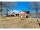 A home exterior showing the brick portion of the home, the fence, and the grassy lawn, with a lovely view of mature trees at 133 Persimmon Creek Rd # 81, Kings Mountain, NC 28086