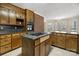 Cozy kitchen with wooden cabinets, brick accent wall, island cooktop, and breakfast area with bay windows at 133 Persimmon Creek Rd # 81, Kings Mountain, NC 28086
