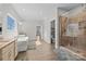 Bathroom features a soaking tub, walk in shower, and wood floors at 13701 Petworth Ct, Charlotte, NC 28278