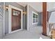 Inviting front porch features stylish lighting, gray siding, and a beautiful wood front door at 13701 Petworth Ct, Charlotte, NC 28278
