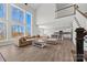 Open-concept living area with large windows, hardwood floors, and a view of the modern kitchen at 13701 Petworth Ct, Charlotte, NC 28278