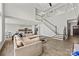 Spacious living room with modern finishes, an open staircase, and a view of the stylish kitchen at 13701 Petworth Ct, Charlotte, NC 28278