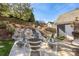 Landscaped backyard with a stone patio, modern outdoor furniture, and a hillside garden at 13725 Mallory Baches Ln, Huntersville, NC 28078
