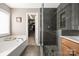 Well-lit bathroom features a soaking tub, a frameless shower, and a walk-in closet at 13725 Mallory Baches Ln, Huntersville, NC 28078