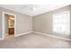 Neutral bedroom with a glimpse into an en-suite bathroom and carpet floors at 13725 Mallory Baches Ln, Huntersville, NC 28078
