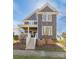 Charming two-story home with gray siding, brick foundation and welcoming front porch with white banister and steps at 13725 Mallory Baches Ln, Huntersville, NC 28078