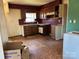 Kitchen with wood cabinets, tile backsplash, damaged floors at 1406 Ratchford Dr, Dallas, NC 28034