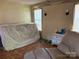 A potential living area with a large covered item, with a vintage armchair and small dresser at 1406 Ratchford Dr, Dallas, NC 28034