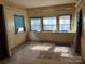 Living room with damaged flooring and water stained window dressings at 1406 Ratchford Dr, Dallas, NC 28034